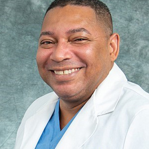 a man in a white lab coat smiling