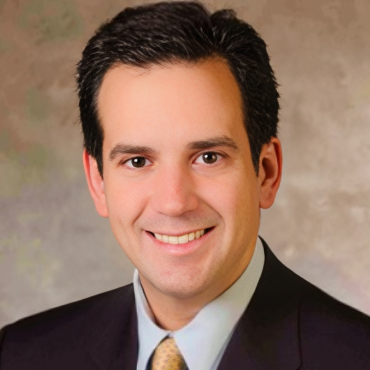 a man in a suit and tie smiling at the camera