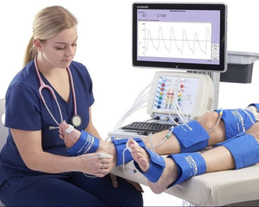 a woman in blue scrubs is using a monitor screen for legs therapy