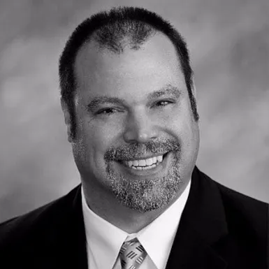 a black and white photo of a smiling man